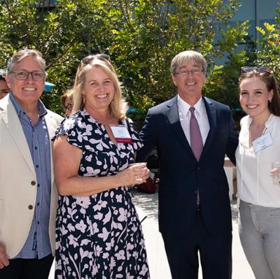 Parents and a student pose with the President of LMU outside during an event.