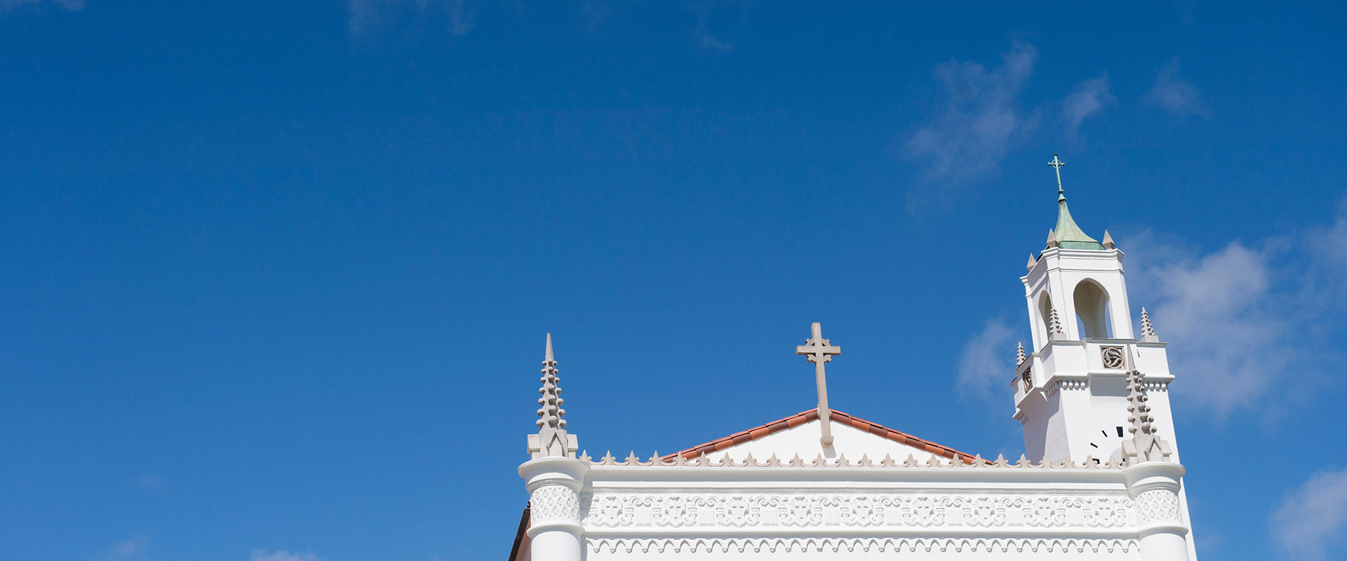 Upward view of the roof of Sacred Heart Chapel and the clock tower