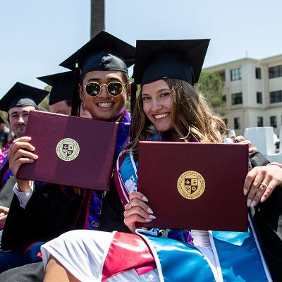 Seniors dressed in cap and gown outside during LMU's commencement ceremony.
