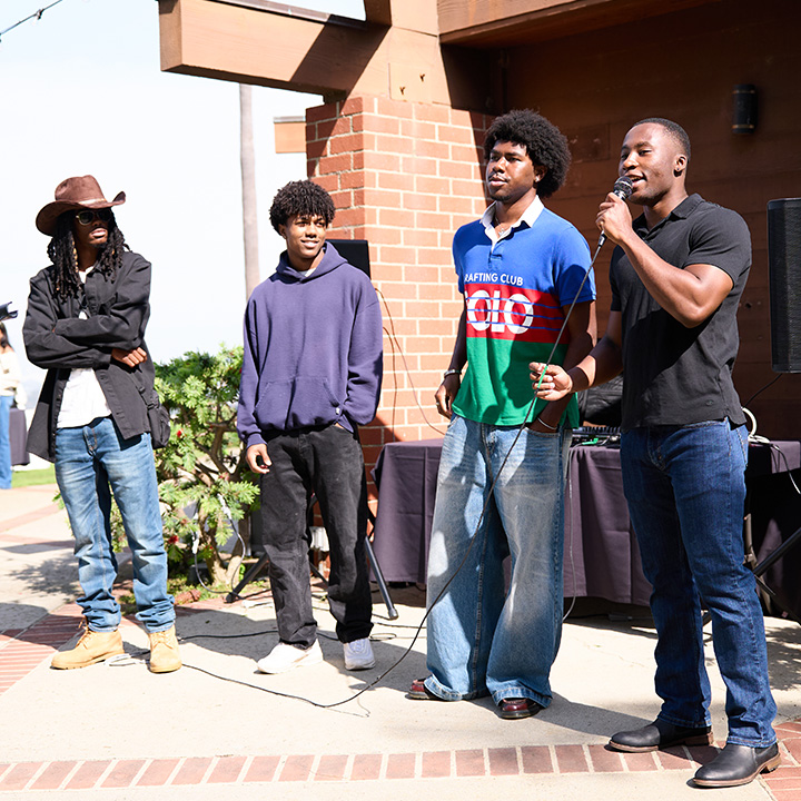 Students stand outside the Mbongi Spot speaking to a crowd during Family Weekend.