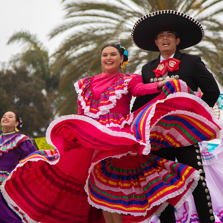 A student from grupo folklorico stands in a traditional folklorico performing.