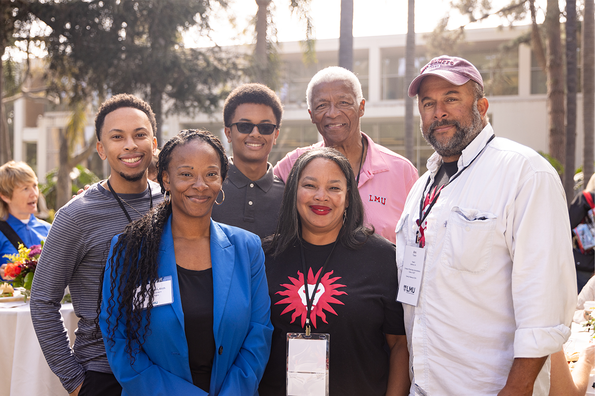 SVP Leggett poses with a family outside during the annual SVP Reception.